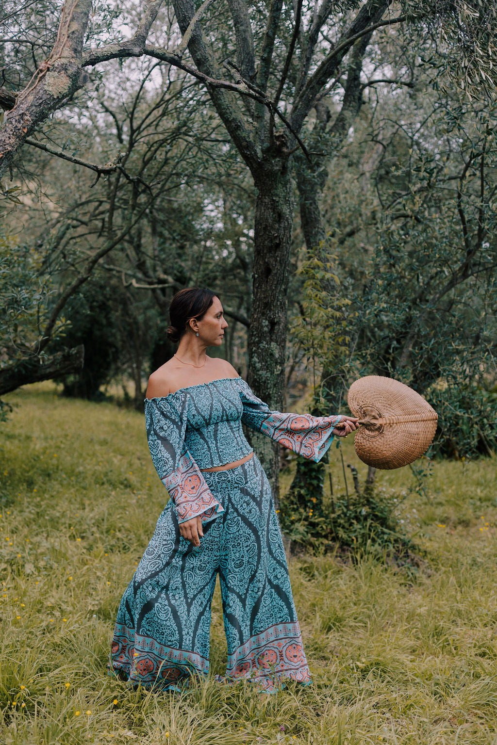 completo estivo boho chic ibiza style in viscosa fresca e leggera azzurro turchese. Il completo è composto da un top arricciato con manica lunga ampia e da un pantalone scampanato effetto panta gonna. Il completo è indossata da una Fate del bosco incantato lapeapois