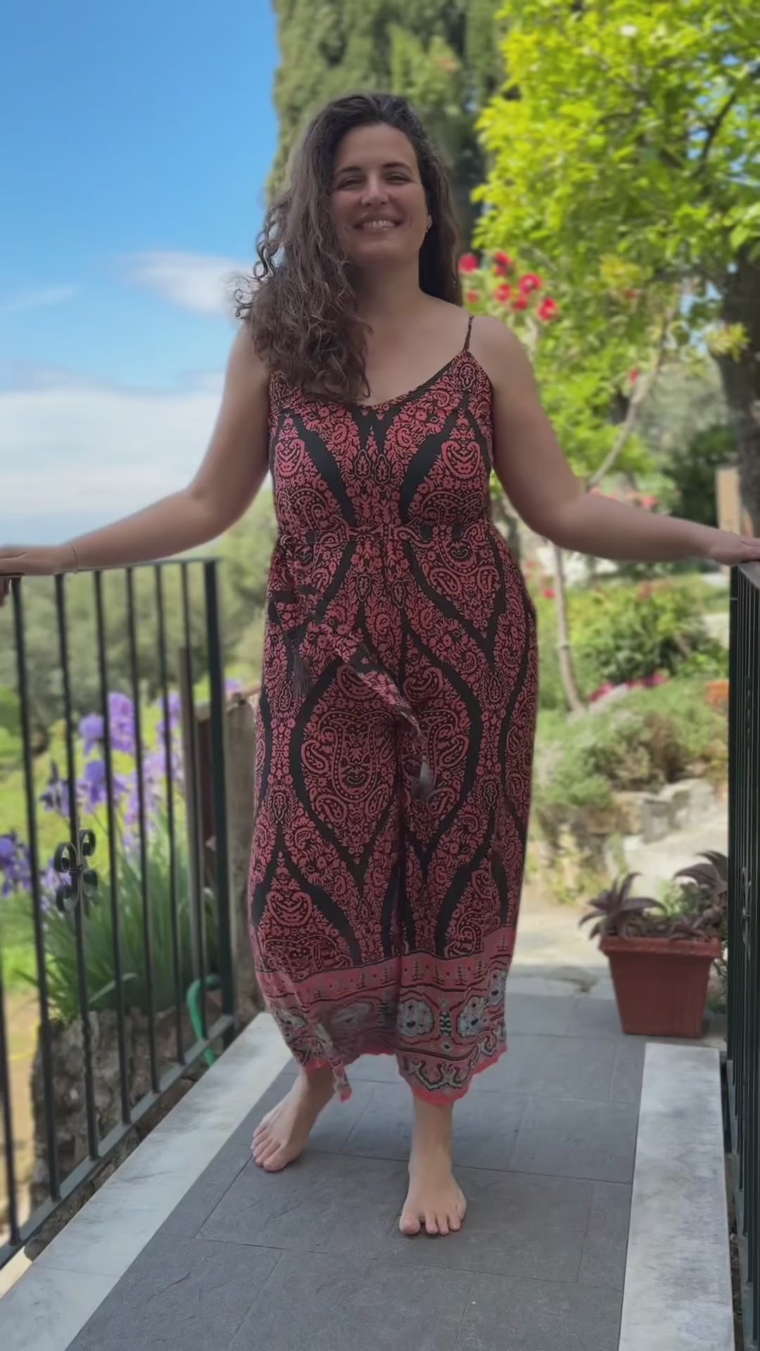Tuta estiva da donna curvy con stampa colorata corallo e nera, gamba ampia per evitare sfregamento cosce e spalline sottili, indossata all'aperto tra gli alberi video lapeapois