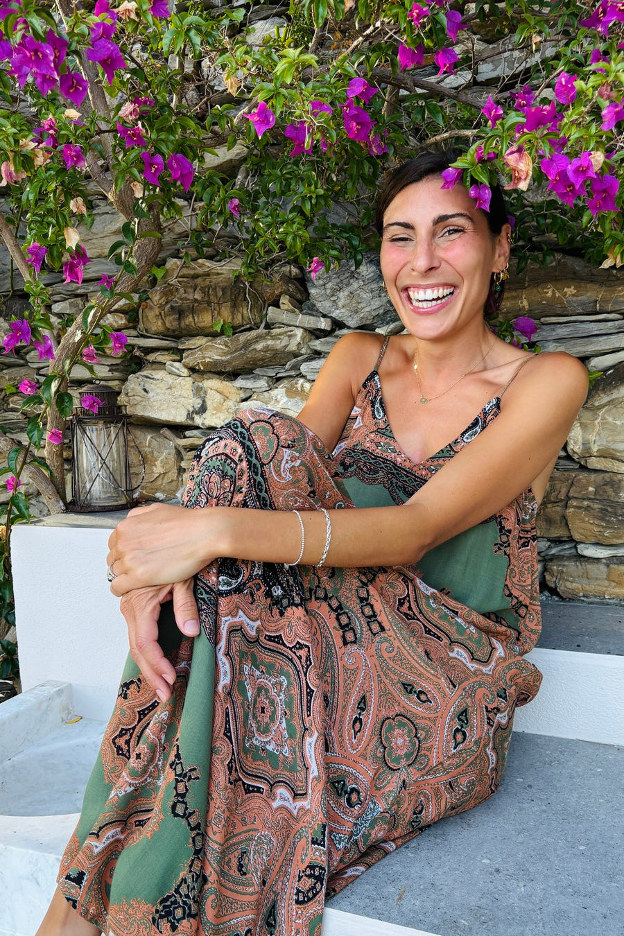 vestito lungo estivo fresco leggero fantasia paisley verde militare indossato da modella sorridente seduta in villa di lusso stile resort wear lifestyle lapeapois